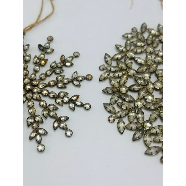 A dazzling pair of vintage rhinestone ornaments featuring intricate openwork designs crafted from faceted clear glass...