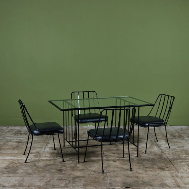 This set features four signature slender, black powder coated wrought iron chairs with a fan-back design using iron rods....