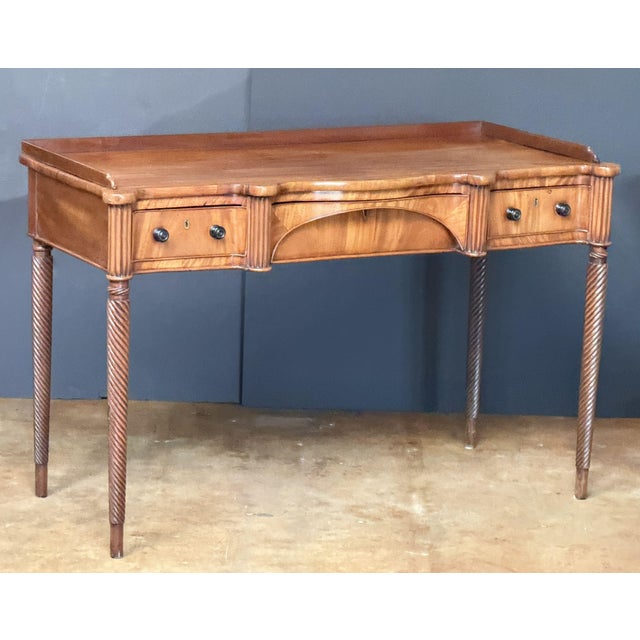 An exquisite Scottish writing table or console desk of mahogany from the Regency period, featuring a beautifully moulded...