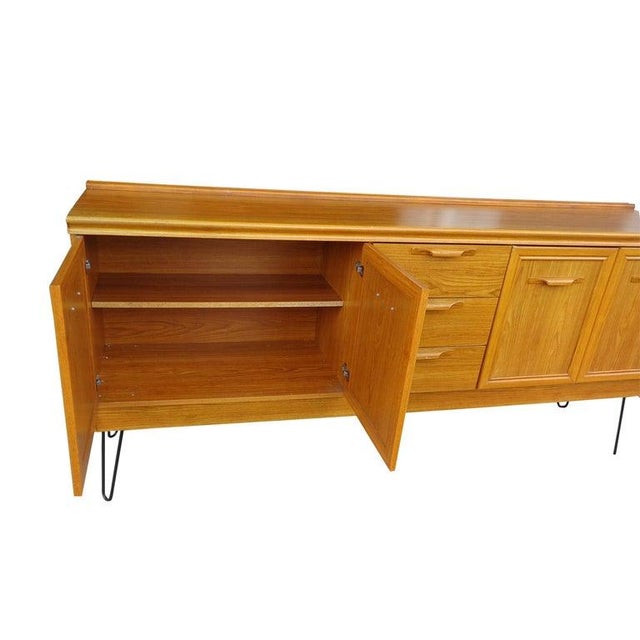 6ft Mid-Century Modern oak sideboard with hair pin legs by Jentique This oak sideboard features a spacious double cupboard...