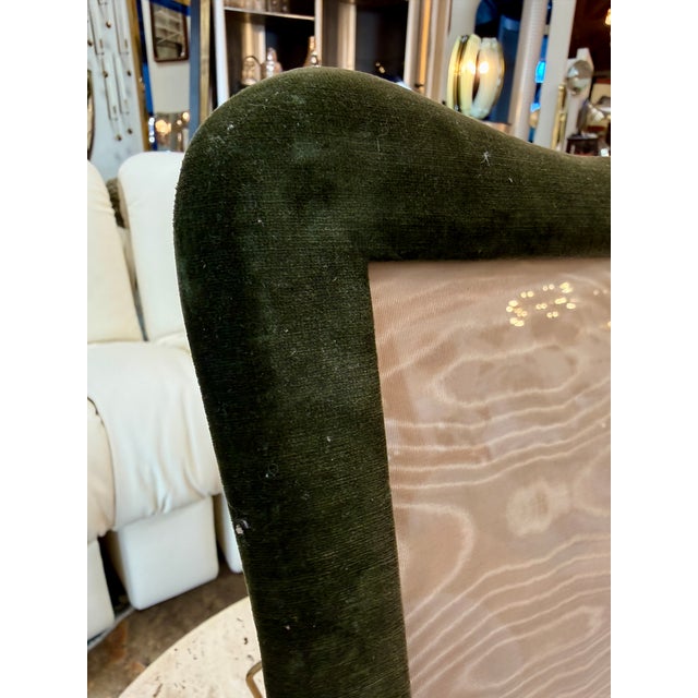Elegant picture frame upholstered in rich forest-green velvet, featuring a softly curved, asymmetrical silhouette with...