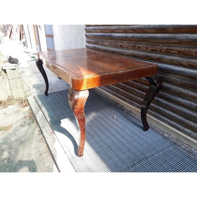 Elegant 1950s dining room table with curved dark wood legs and light wood veneer top, built in the 1950s. Measurements:...