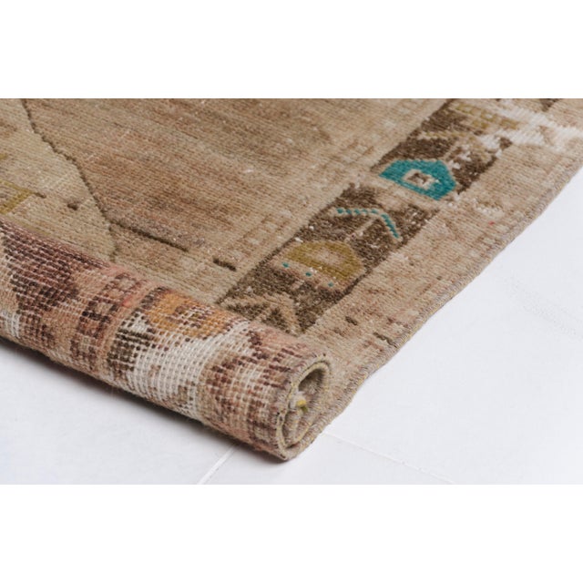 This is a vintage Turkish Oushak rug from the Mid 20th Century. The piece was hand-knotted.