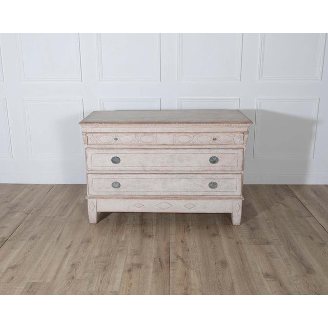 A distinctive early 19th-century Danish chest of drawers, painted in a soft antique white with warm undertones that...