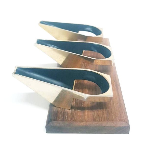 Mid century desk pipe holder for 3 pipes. The metal holders are mounted on a polished wood base with beveled edges. The...