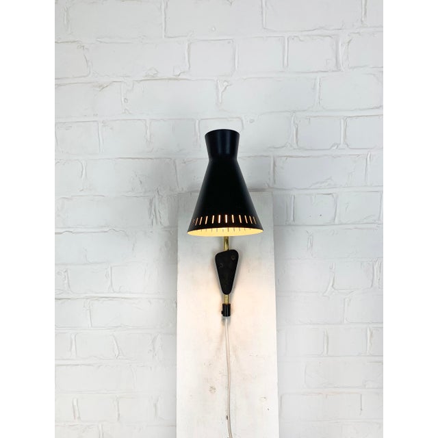 Small modernist model 215 wall light produced by eae in sweden during the 1950s. the lamp features a distinctive metal...