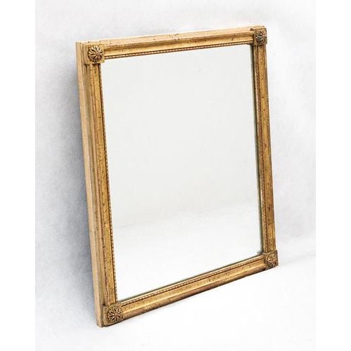 19th century french louis xvi giltwood mirror with floral corner details. this elegant 19th century french louis xvi style...