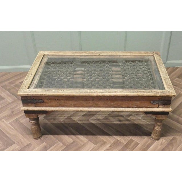 A Heavy Coffee Table with Inset Iron Grill Panel This table is made from a 19th century North African Door. It has a solid...
