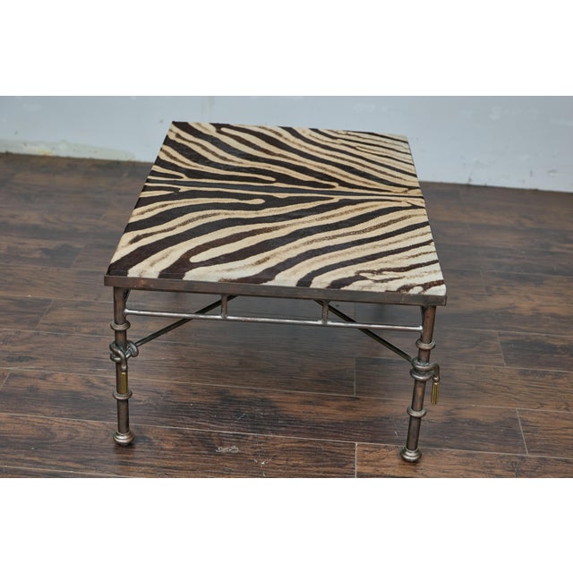 A Midcentury metal coffee table with zebra hide top and petite gilt metal tassels. This striking midcentury metal coffee...