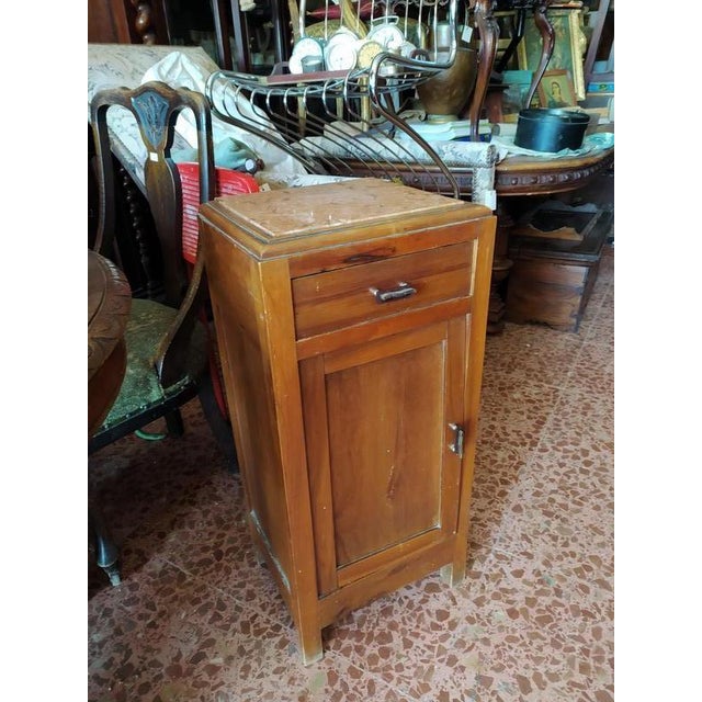 Bedside table with pink marble stone and handles with metal parts and bakelite parts original from the period. Made of...