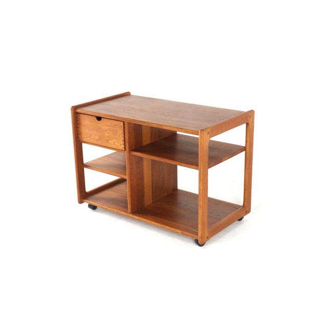 Sleek teak trolley. This trolley owes its beautiful timeless look to the straight lines in its design, both horizontally...