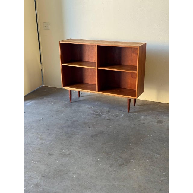 Danish Modern teak bookcase, 1960s, featuring clean Scandinavian lines and warm teak grain throughout. The piece offers...