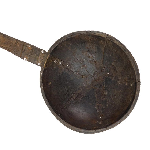 A large spoon or scoop made out of wood carved with a large bowl and a long handle with aluminum designs. Height (In):Â...