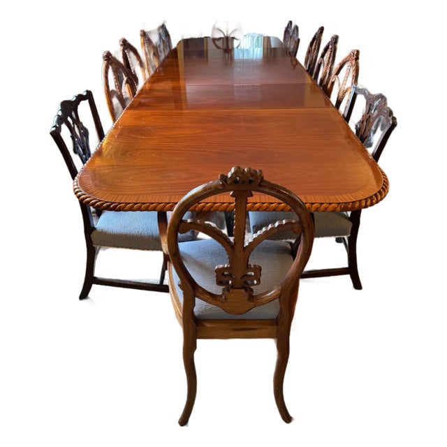 Substantial antique English mahogany dining suite comprising an expandable pedestal table and fourteen coordinating...