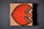 Decorative ceramic wall tile by Søholm, with a raised fish motif in warm orange and brown glazes. The piece has a textured...