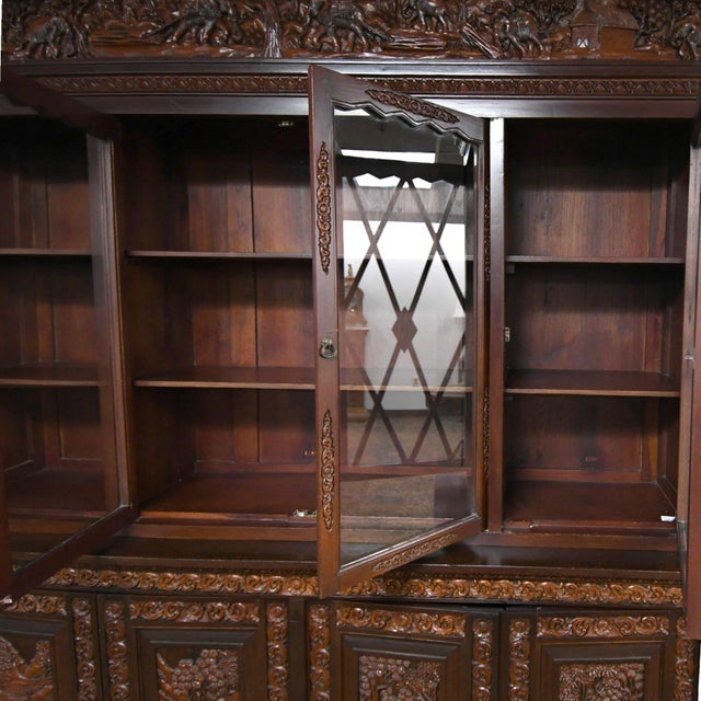 This exquisite Early 20th-century Antique Hand-Carved Wood China Cabinet features intricate animal and nature scenes. With...