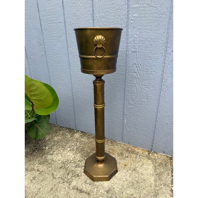 Vintage solid brass wine or champagne bucket on stand. Decorative shell and ring handles with hammered accent on bucket....