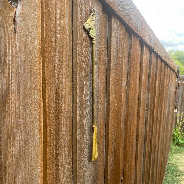 Solid cast brass shoe horn with horse head finial handle with small ring for hanging. Longer shoe horn than most making it...