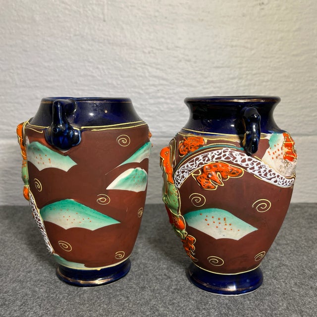 Colors of cobalt blue, brick red, and burnt orange with raised reliefs of Geisha’s riding both a dragon and elephant with...