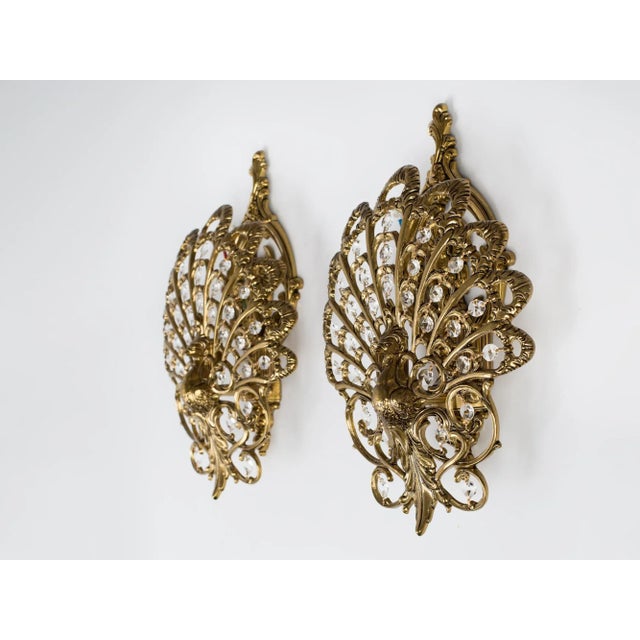 Vintage, elegant pair of peacock two-light wall sconces. The peacocks have lovely brass bodies, their tails are made of...