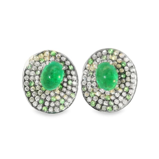 These huggie earrings are crafted in 18K white gold and feature 2 cabochon emeralds per earring , along with numerous...