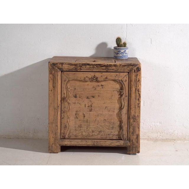 Low cabinet with a single door in elm wood, originating from shanxi province in northern china and dating to circa 1930. A...