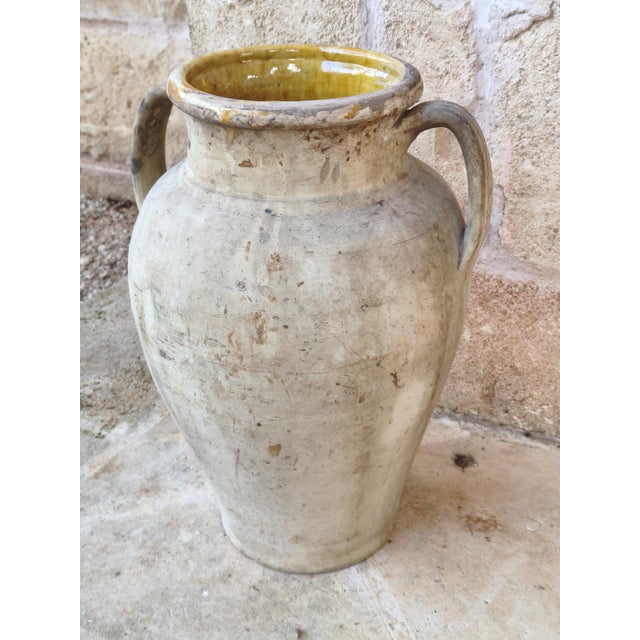 Antique terracotta jar with two handles and a honey-yellow glazed interior, typical of southern Italian country homes....