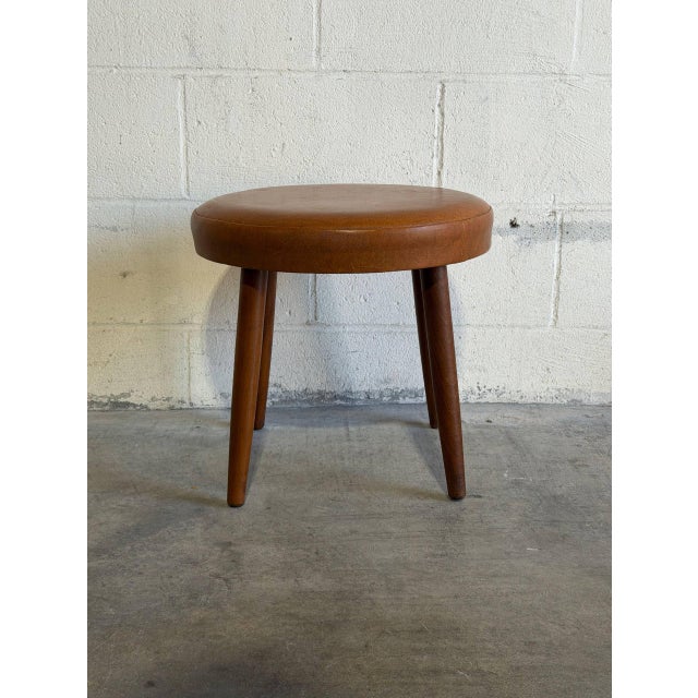 Featuring a cushioned circular top elevated by tapered legs, this stool offers a minimal organic profile. Its clean form...