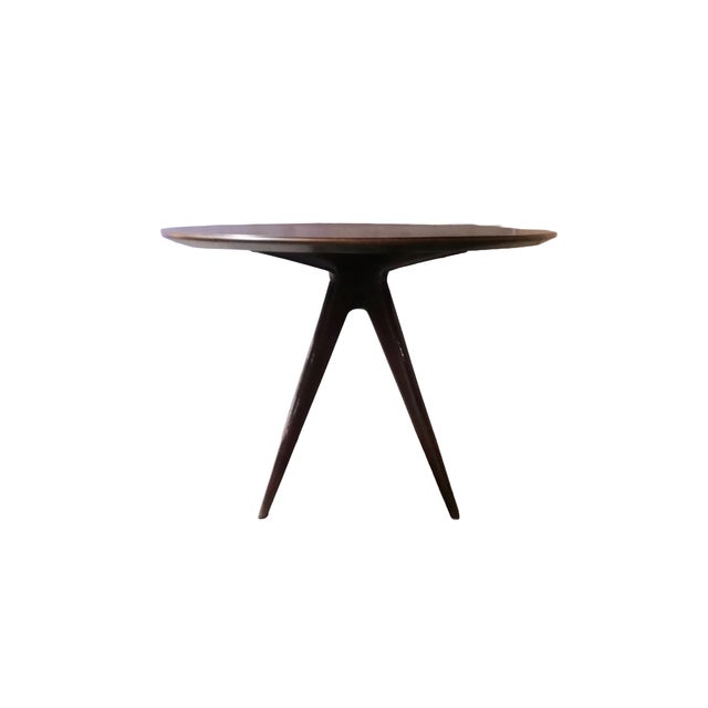 Round table with a modern shape attributed to Osvaldo Borsani. Four solid wood legs. Laminate top with an elegant flared...