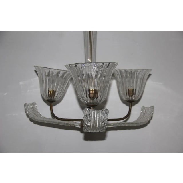This chandelier from the 1940s is made of Murano glass with brass elements. The brass can be polished to achieve a shiny...