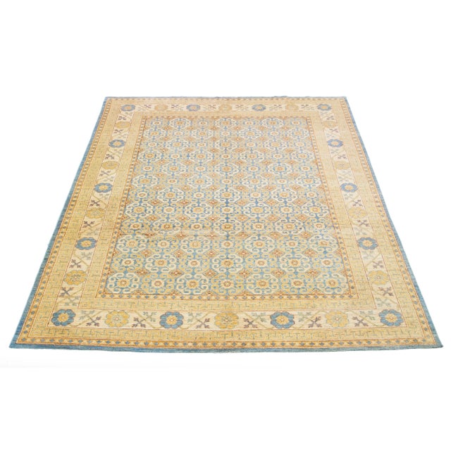 This is a beautiful modern Khotan hand-knotted wool rug with a beige field. Its gorgeous design features blue and brown...