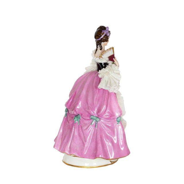 A Capadimonte's charming porcelain figure depicts a baroque styled woman dressed in pink and holding a fan. This piece is...