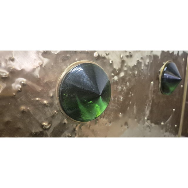 This stunning brass and black glass sideboard with 18 green Murano jewels is a masterpiece of Italian craftsmanship that...
