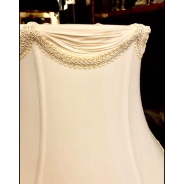 A tailor made draped eggshell silk bell lamp shade having a beautiful row of silk swags trimmed with gimp around the top...