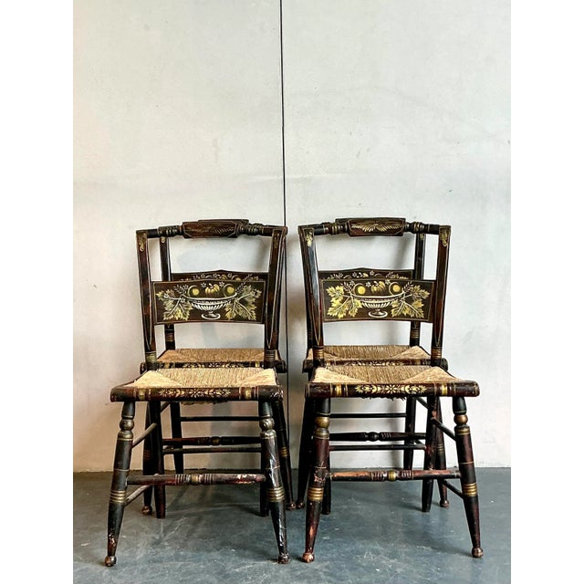 This charming set of four vintage Hitchcock chairs embodies a delightful blend of Americana folk art and rustic elegance....
