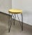 Great, minimalistic metal stool with tripod hairpin legs. Black metal with a round seat in a mustard yellow colour....