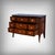 This chest of drawers, veneered in mahogany and precious woods, seems to carry within it the whisper of time. Born in the...