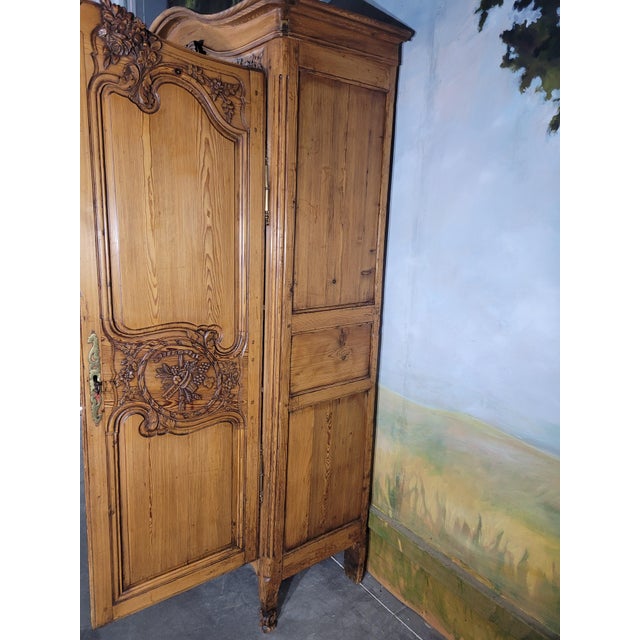 An elegant antique louis xv style wardrobe, crafted from solid fir, showcasing exquisite hand-carved details. The front is...