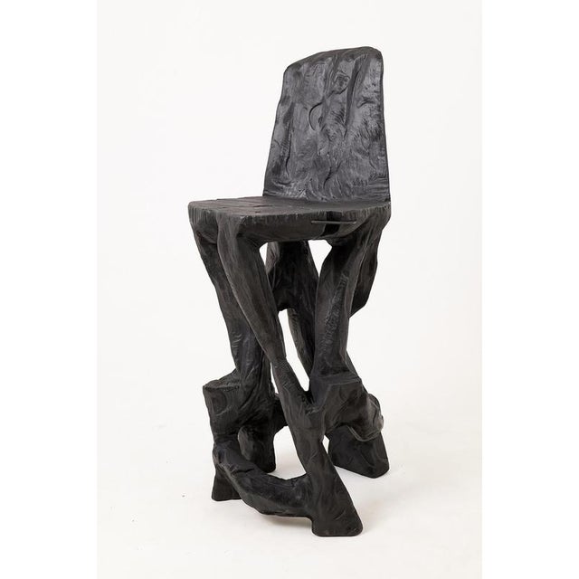 This sculptural chair is a singular expression of raw craftsmanship, carved by hand from a solid hardwood log and...