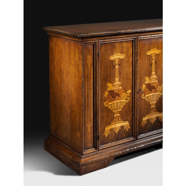Handcrafted in Italy, this sideboard features richly figured walnut veneers accented with decorative marquetry inlays. The...