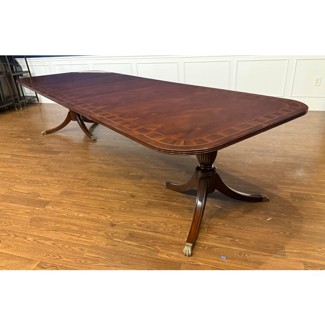 This is a Traditional Multi-Banded Mahogany Dining Table by Leighton Hall Furniture. It features a field of swirly crotch...