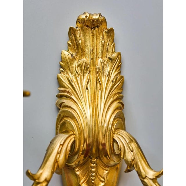 Antique wall lamp / sconce made of cast brass in a classicist style with floral decoration. Robust body with a large...