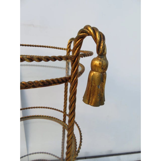 Hollywood Regency metal gold gilt rope twist stand with tassels, 3 glass shelves .