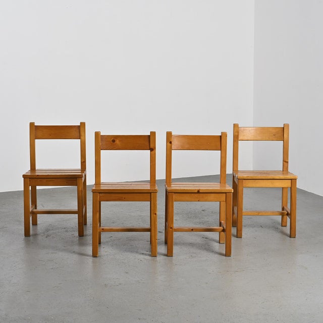 Set of four solid pine chairs by Maison Regain. The seat is made up of 3 wide slats and the solid backrest is slightly...