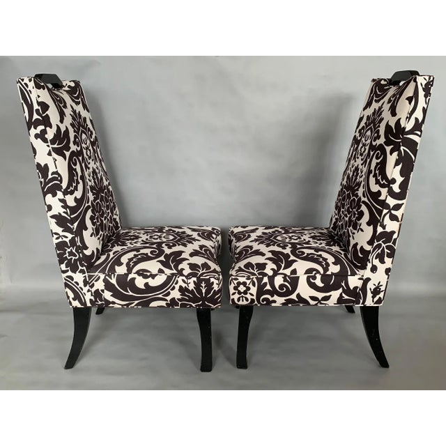 A pair of unusual decorator chairs with high back and handles.