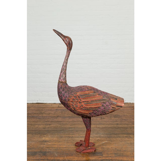 A vintage Indonesian hand carved heron sculpture from the mid-20th century, with polychrome finish. Hand carved in...