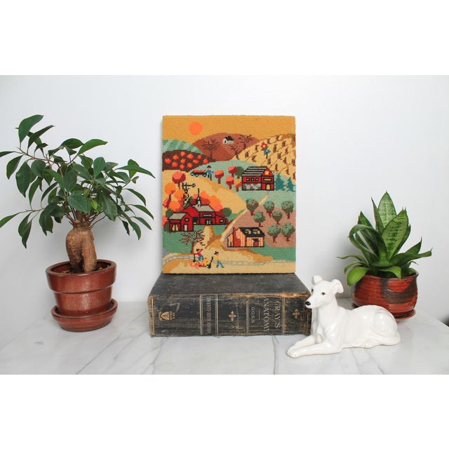 Unframed folk art / Americana textile wall hanging of a country farm scene with red barns, rolling hills, trees, and...