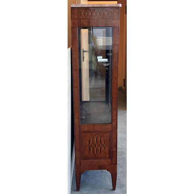 Louis XVI style showcase from the early 19th century. It presents a beautiful geometrical marquetry on the facade as on...