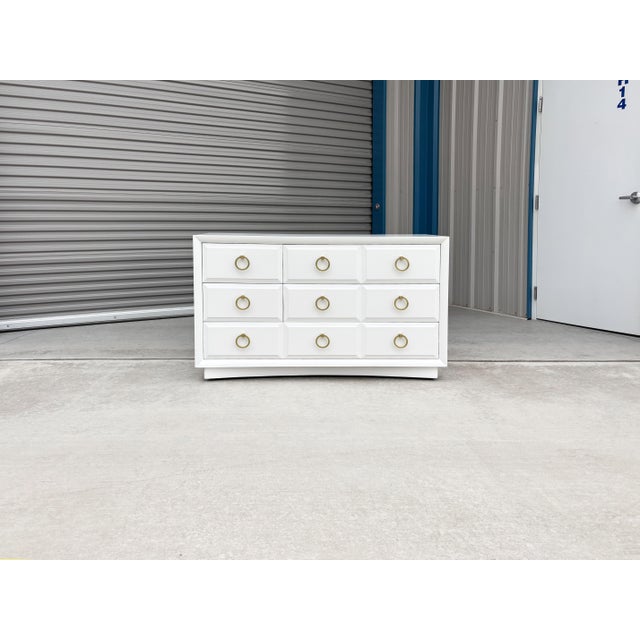 Mid-century white and brass dresser designed by T.H. Robsjohn-Gibbings for Widdicomb, United States, circa 1960s. This...