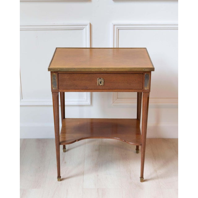 A finely crafted Louis XVI–style writing table by André Mailfert, produced in France during the mid-twentieth century....
